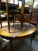 A retro teak circular extending dining table and four chairs