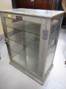 A vintage painted metal and glass cigar retail display