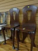 A pair of dark wood hall chairs