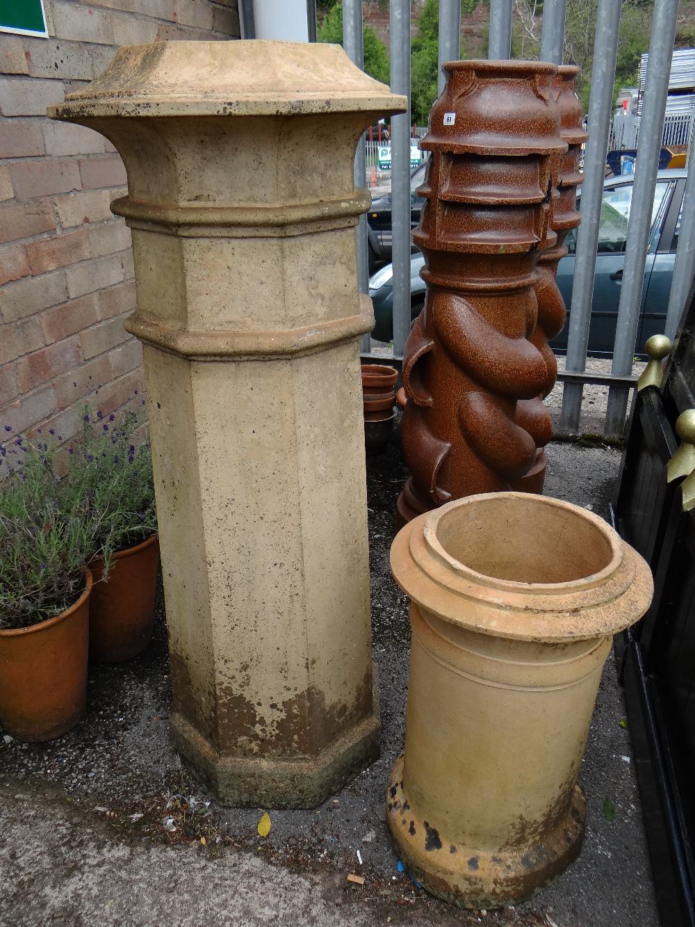 A pale terracotta tall chimney pot together with another