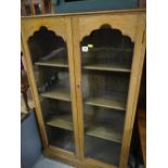 A vintage oak two-door glazed bookcase together with a small oak nursing chair with Art Nouveau tap