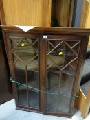 An antique two-door glazed hanging corner cupboard