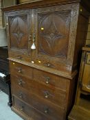 A vintage oak carved tallboy comprising three long and two short drawers, middle narrow drawer and