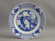 A CHINESE BLUE & WHITE DECORATED PORCELAIN PLATE, the centre depicting a garden scene of young women