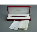 A CARTIER STYLO BILLE MUST II RED LACQUER BALLPOINT PEN, no. 593002 with original booklets