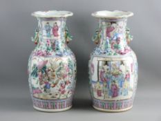 A PAIR OF 19th CENTURY CHINESE FAMILLE ROSE DECORATED VASES, decorated with panels of fighting