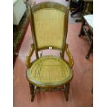 A CIRCA 1900 WALNUT ROCKING CHAIR, the top rail with burr walnut decoration, cane work back and seat