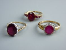 THREE NINE CARAT GOLD DRESS RINGS, two with oval red stones, one with flanking stones and another