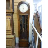 AN ART DECO OAK CASED TRIPLE WEIGHT LONGCASE CLOCK, the arched top case having a long front door