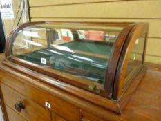 A VICTORIAN MAHOGANY COUNTER TOP DISPLAY CASE having a convex glass lid and shaped side panels