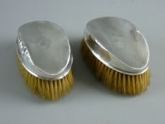 A PAIR OF SILVER BACKED GENT'S BRUSHES, circa Birmingham 1925 (crushed damage to rim of one)