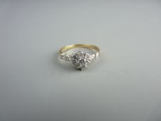 AN EIGHTEEN CARAT GOLD SEVEN STONE MOISSANITE CLUSTER RING with two flanking stones each side,