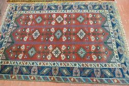 AN ALL WOOL TURKISH RUG, triple bordered with a central red ground having a three section repeated