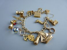 A NINE CARAT GOLD LINK CHARM BRACELET with safety chain and padlock and approximately fourteen