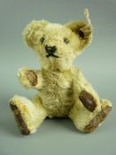 A MINIATURE STEIFF TEDDY BEAR with button eyes, stitched nose and mouth, jointed limbs with