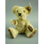 A MINIATURE STEIFF TEDDY BEAR with button eyes, stitched nose and mouth, jointed limbs with