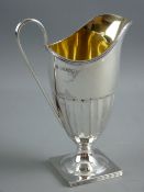 A HALLMARKED SILVER HELMET SHAPED CREAM JUG, London 1883 by William Hutton, the pedestal jug with