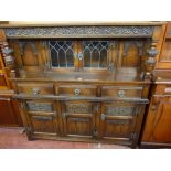 A REPRODUCTION JACOBEAN STYLE BUFFET SIDEBOARD with linenfold and other carved decoration having