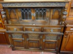 A REPRODUCTION JACOBEAN STYLE BUFFET SIDEBOARD with linenfold and other carved decoration having