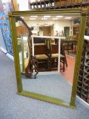 A REPRODUCTION REGENCY STYLE OVERMANTEL MIRROR in green and gilt livery, 124 cms high, 96 cms wide