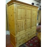 A MODERN PINE TRIPLE WARDROBE with three short and two long base drawers having turned wooden