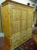 A MODERN PINE TRIPLE WARDROBE with three short and two long base drawers having turned wooden