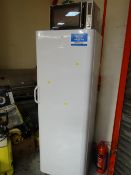 An Indesit upright freezer together with a Silvercrest microwave oven