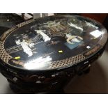 A late twentieth century fancy oval Japanese-style nest of tables in black lacquer with mounted