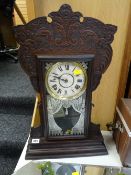 An American antique mantel clock in a carved wooden frame
