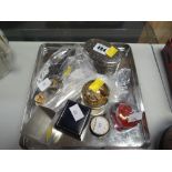 A tin tray of items including two glass paperweights, a silver ladies' fob watch and small items
