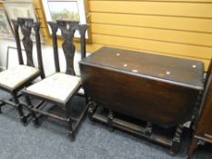 A stained vintage barley-twist gate leg table and two carved stained chairs with drop in seats