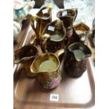 Seven copper lustre jugs