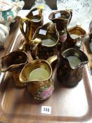 Seven copper lustre jugs