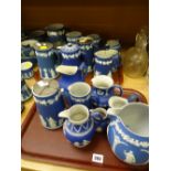 A large quantity of blue Wedgwood Jasperware jugs with EPNS lids