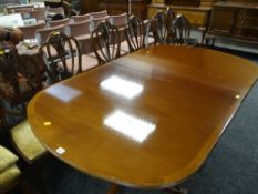 A reproduction Regency-style extending dining table with one leaf and eight Prince of Wales