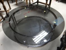 A retro circular smoky glass and chrome coffee table