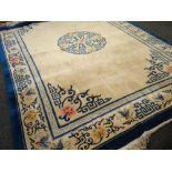 A large Oriental ivory and blue bordered rug, 365 x 274cms
