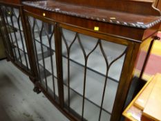 A vintage bow front two-door glazed china cabinet on ball and claw supports