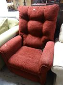 A red floral covered electric recliner armchair