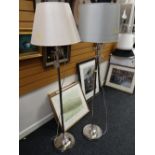 A pair of chrome column standard lamps and shades