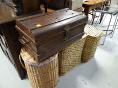A vintage tin travel trunk and three modern laundry baskets
