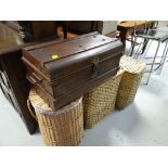 A vintage tin travel trunk and three modern laundry baskets