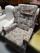 A floral covered reclining wingback armchair