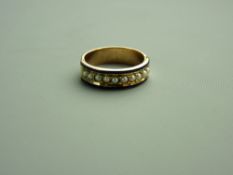 A WIDE GOLD (unmarked) PEARL & ENAMEL HALF ROUND MEMORIAL RING having a band of ten small pearls