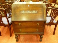 A 1930's OAK FALL FRONT BUREAU, the slope fall with carved front decoration, interior writing