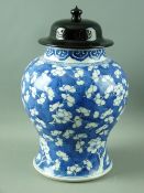 A CHINESE 18th CENTURY KANGXI PRUNUS JAR with ebonized wooden cover, of bulbous waisted form with