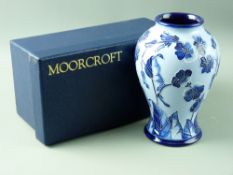 A MOORCROFT MODERN FLORIAN TYPE BALUSTER VASE, having a two tone leaf and floral pattern on a sky