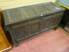 AN ANTIQUE OAK COFFER, the lidded top with four inset panels with iron nail hinges, interior