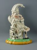 A STAFFORDSHIRE FLATBACK FIGURE OF MR PUNCH seated with his dog by his side, the face with painted