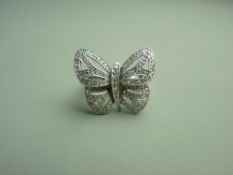 A NINE CARAT WHITE GOLD DIAMOND ENCRUSTED BUTTERFLY DRESS RING, having approximately one hundred and